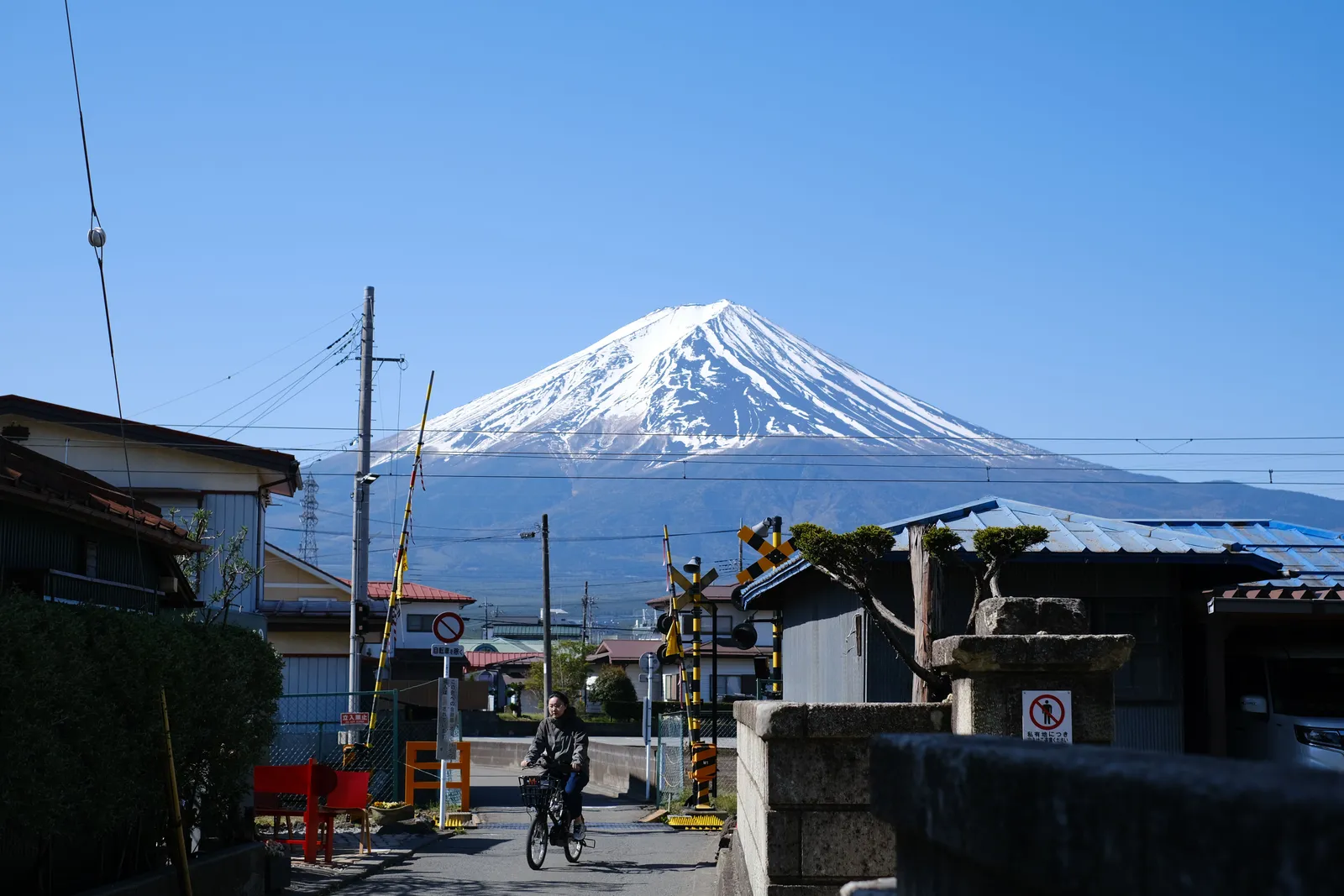 A white shinkansen bullet train passing below Mount Fuji on a clear day in Japan