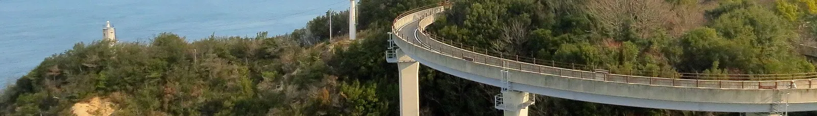 A curving elevated cycle ramp on the Shimanami Kaido climbing towards a bridge deck