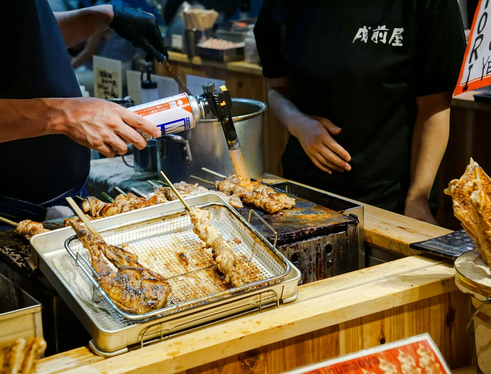 A sizzling okonomiyaki savory pancake cooking on a hot griddle at a street stall in Japan