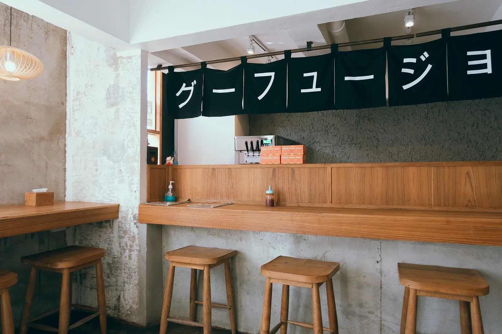 An empty counter lined with stools in a small Japanese restaurant