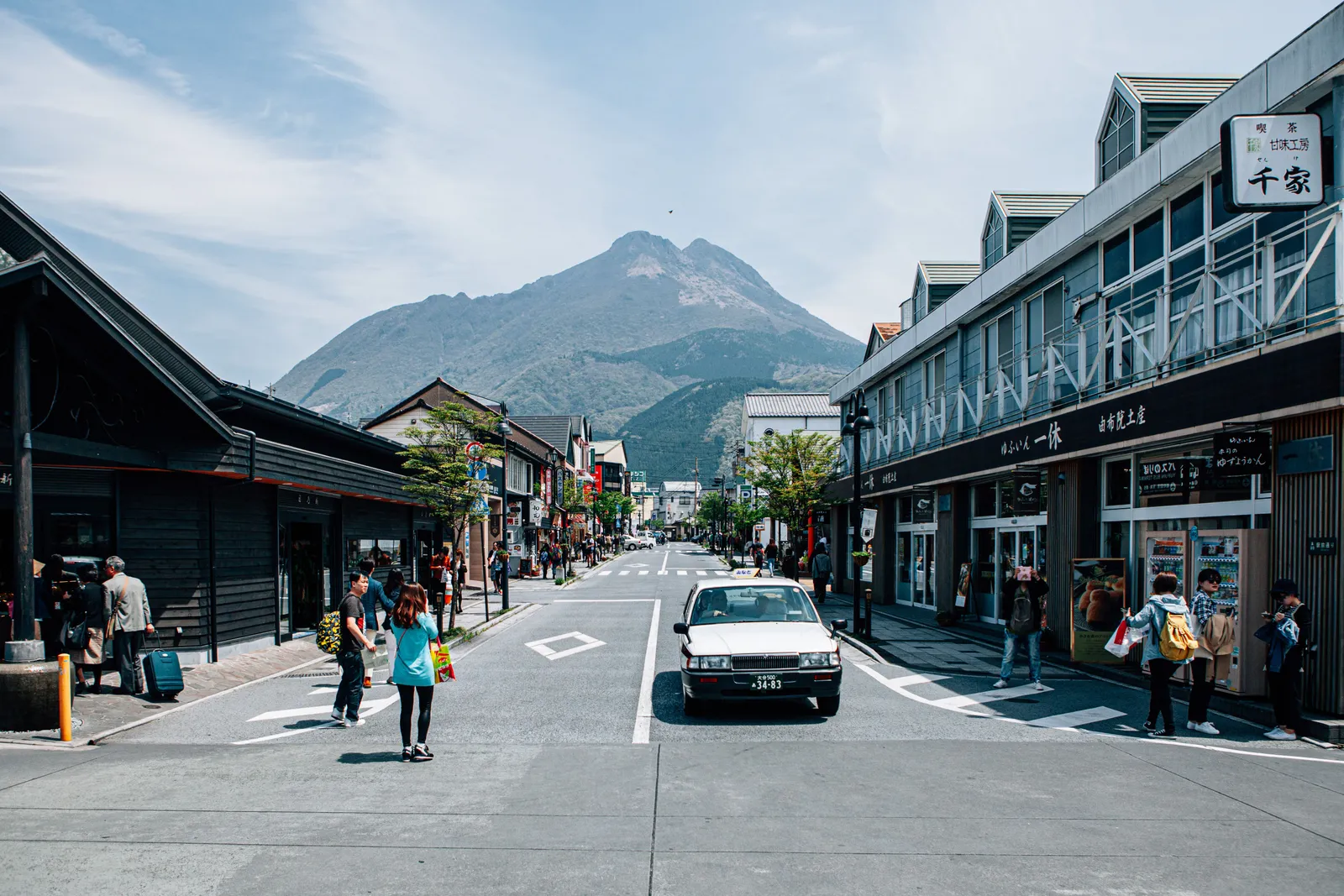 The main street of Yufuin with its shops and Mount Yufu rising behind them